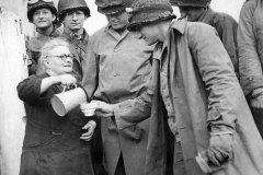 Elderly_woman_pours_milk_for_soldiers_in_the_Normandy_area_of_France