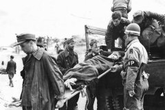 German_Prisoners_Unload_Wounded_Comrade_on_Normandy_Beachhead_1944