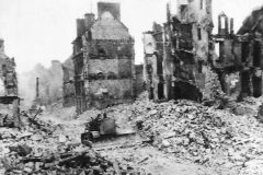 US_Army_engineers_use_bulldozer_to_force_a_path_through_street_in_war-shattered_Valognes_Normady_France_1944