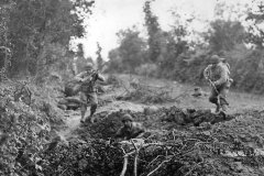 US_Infantrymen_leap_for_safety_of_shell_hole_in_Normandy