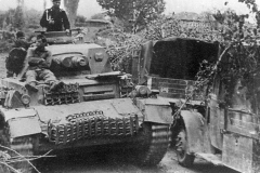 Panzer_IV_Ausf_C_passing_trucks_on_road