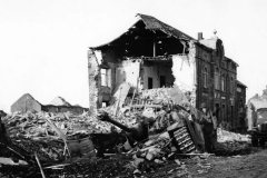 Soldier_by_Wreckage_of_German_StuG_40_ausf_G_in_Noville_1944